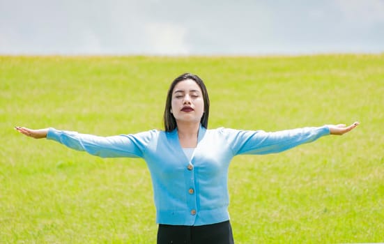 A girl spreading her arms in the field, Attractive young woman spreading her arms in the field, concept of free woman spreading her hands