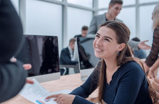 smiling young business woman sitting at an office Desk. business people