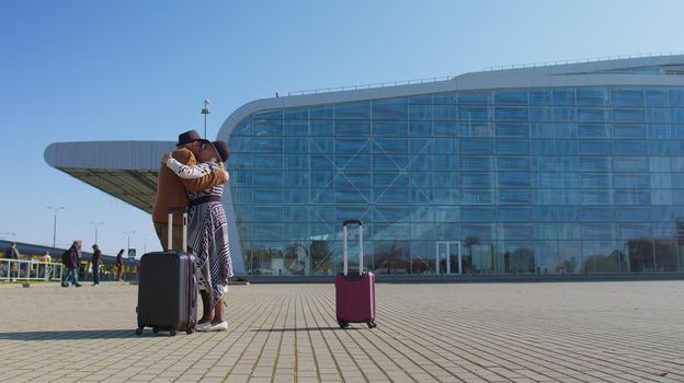 Senior old husband meet wife retirees tourists reunion near airport terminal. Long-awaited meeting. Grandmother grandfather hugging meeting after long flight vacations, trip work, coronavirus lockdown