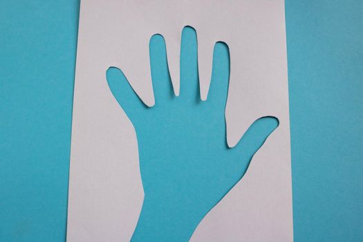 On a blue background, a white paper palm stencil.