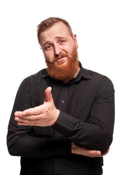 Portrait of a young, chubby, redheaded man with a beard in a black shirt, gesticulating and looking at the camera, isolated on a white background