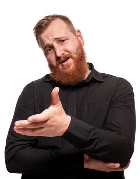 Portrait of a young, redheaded man with a beard in a black shirt, gesticulating and looking at the camera, isolated on a white background