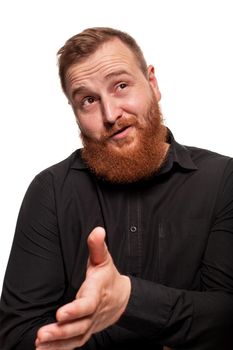 Portrait of a young, chubby, redheaded man with a beard in a black shirt, gesticulating and looking away, isolated on a white background