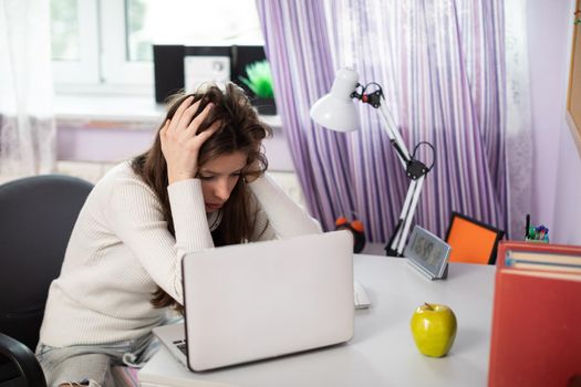 A young student doubts that she can learn enough topics for tomorrow's test. The girl doubts that she will be able to learn enough for her school class.