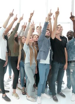 group of diverse young people pointing upwards. photo with copy space