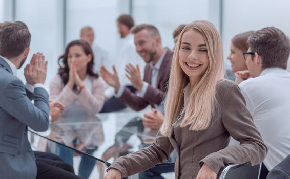 smiling young woman sitting at table in conference room . business concept