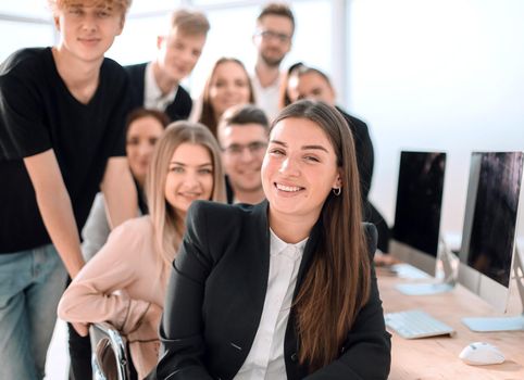 portrait of a young business woman against the background of her colleagues