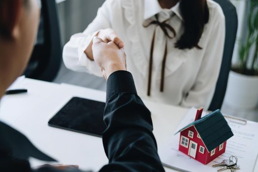 Guarantees, Mortgages, Signings, Insurance, contract, agreement concept, Real Estate Agents are shaking hands with customers to congratulate them after landing a deal.