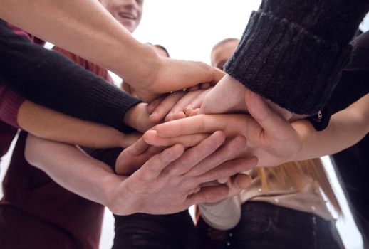 group of diverse young people making a tower out of their hands. the concept of unity