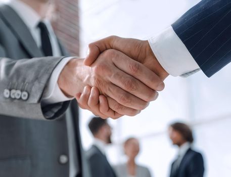 closeup.reliable handshake of business partners on the background of business team