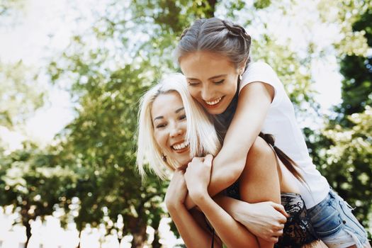 Young woman riding piggyback on friend