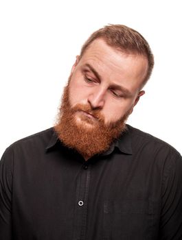 Portrait of a young, handsome, chubby, redheaded man with a beard in a black shirt, looking down, isolated on a white background