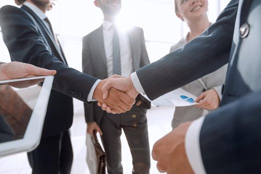 employees look at the handshake business partners.the concept of teamwork