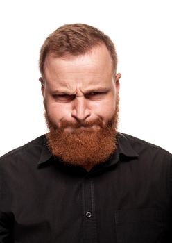 Portrait of a young, chubby, redheaded man with a beard in a black shirt, crooking at the camera, isolated on a white background