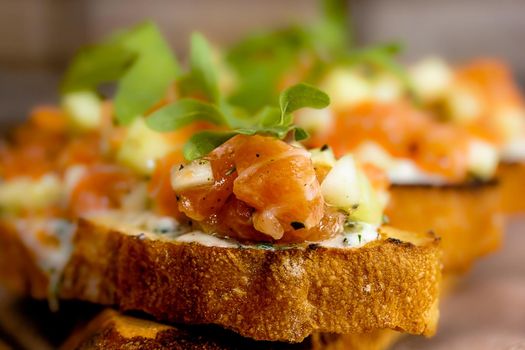 dry aged smoked salmon on the slices of bread and cream cheese sandwiches with cherry tomatoes and rocket salad.