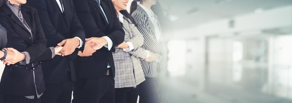 Successful business people standing together showing strong relationship of worker community. A team of businessman and businesswoman expressing a strong group teamwork at office broaden view