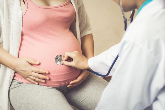 Happy pregnant woman visit gynecologist doctor at hospital or medical clinic for pregnancy consultant. Doctor examine pregnant belly for baby and mother healthcare check up. Gynecology concept.