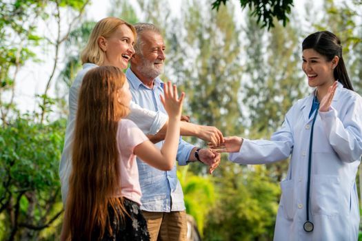 Happy healthy family and doctor talking in the park. People healthcare and medical staff service concept.