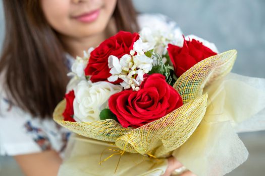 Happy woman gets rose bouquet gift from her boyfriend on Valentines day. Couple love lifestyle concept.