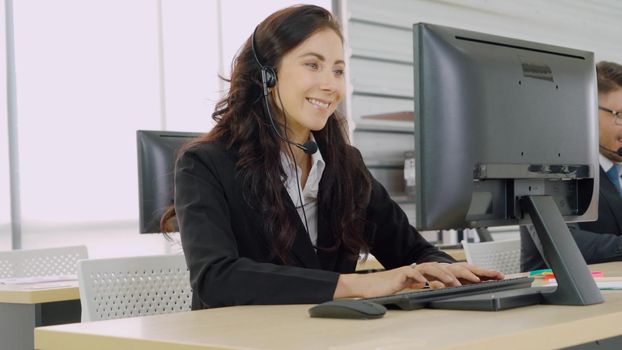 Business people wearing headset working in office to support remote customer or colleague. Call center, telemarketing, customer support agent provide service on telephone video conference call.