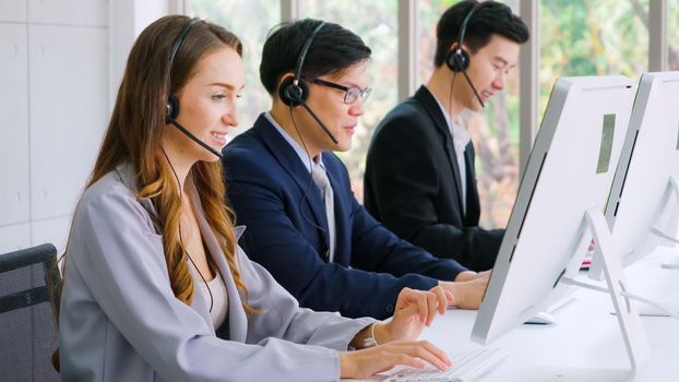 Business people wearing headset working in office to support remote customer or colleague. Call center, telemarketing, customer support agent provide service on telephone video conference call.