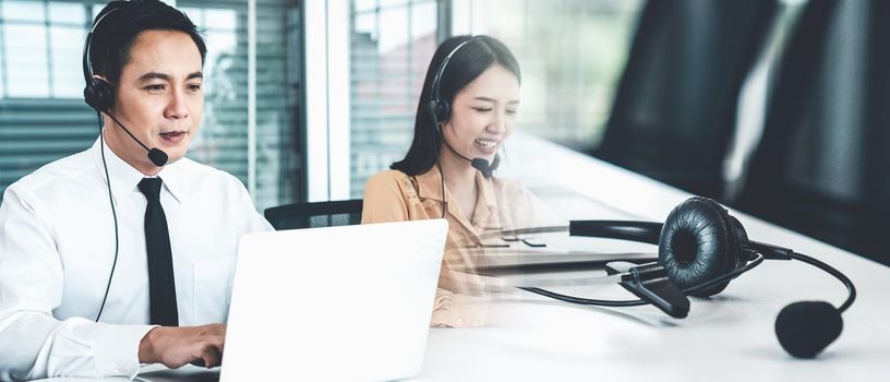 Business team wearing headset working actively in office . Call center, telemarketing, customer support agent provide service on telephone video conference call.