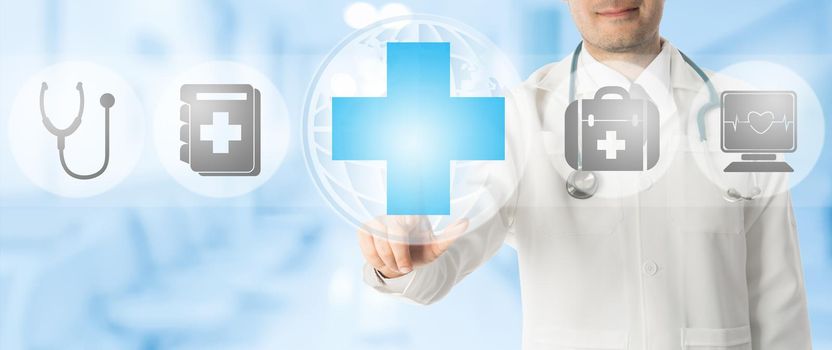 Healthcare Concept - Doctor points at medical cross with other medical icons showing patient caring and health examination technology display on blue abstract background.