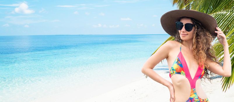 Happy young woman wearing swimsuit at tropical sand beach resort in summer for holiday travel vacation.