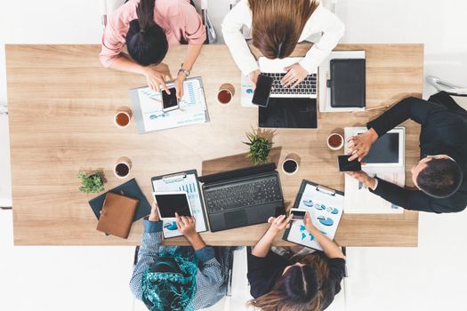 Top view of businessman executive in group meeting with other businessmen and businesswomen in modern office with laptop computer, coffee and document on table. People corporate business team concept.