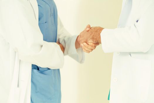 GP doctor shake hand with surgical doctor on white background.