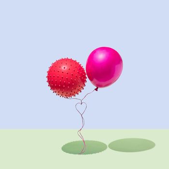 Two balloons with ropes that form a heart isolated on a blue and geeen background. The concept of Valentine's Day and love. Square layout. Minimal.