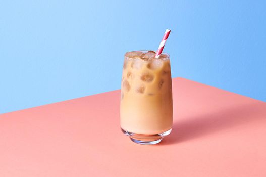 Iced Coffee with Milk in Tall Glasses on Pink Table and Blue Background. Isometric Horizontal Orientation.