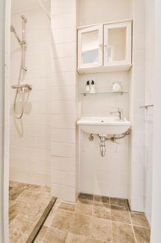 Fragment of interior of modern white bathroom with shower box and sink