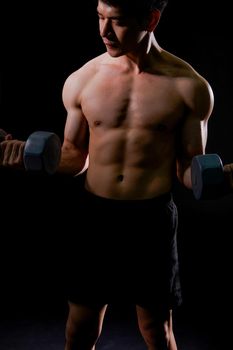 portrait of athletic muscular bodybuilder man with naked torso six pack abs working out with dumbbell. fitness sport exercise concept