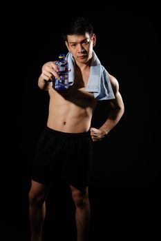 portrait of athletic muscular bodybuilder man with naked torso six pack abs holding water bottle. fitness workout concept