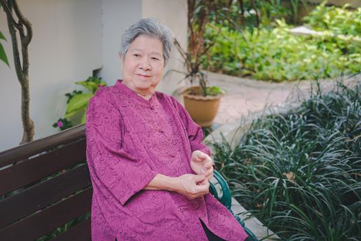 old elder woman resting in garden. asian elderly female relaxing in park. senior leisure lifestyle