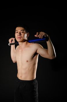 portrait of athletic muscular bodybuilder man with naked torso six pack abs holding baseball bat. fitness workout concept