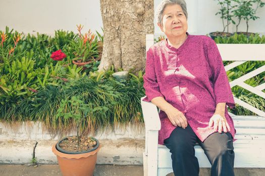 old elder woman resting in garden. asian elderly female relaxing in park. senior leisure lifestyle