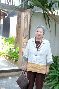 old elder woman resting in garden. asian elderly female relaxing outdoors. senior leisure lifestyle