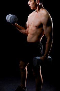 portrait of athletic muscular bodybuilder man with naked torso six pack abs working out with dumbbell. fitness sport exercise concept