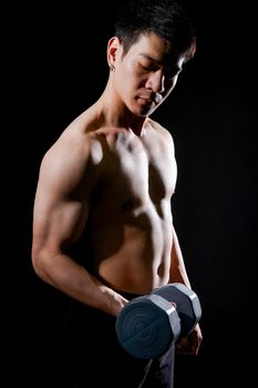 portrait of athletic muscular bodybuilder man with naked torso six pack abs working out with dumbbell. fitness sport exercise concept