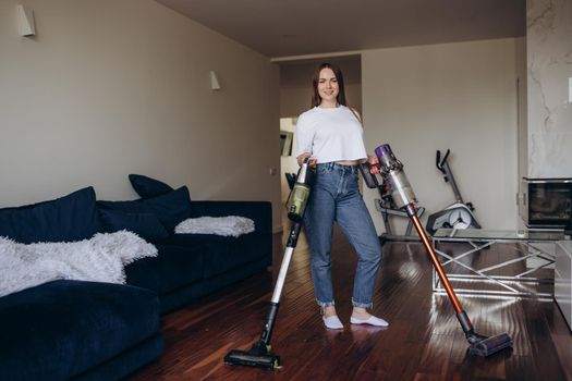 Young Maid Cleaning Carpet With Vacuum Cleaner At Home.