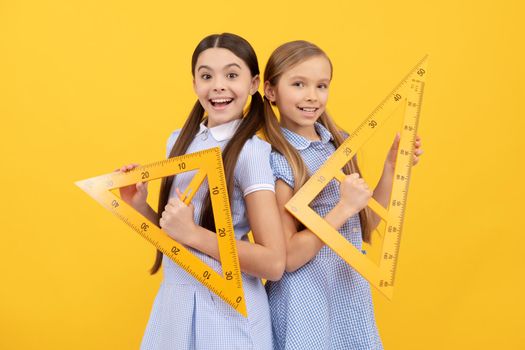 Education for all children. Happy teen girls hold triangular rulers. School education. Geometry lesson. Knowledge day. September 1.