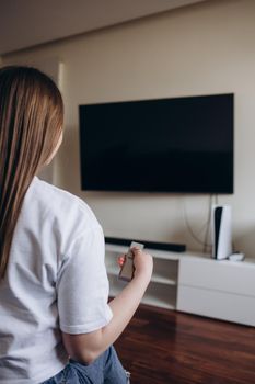 Young woman watching TV in the room.