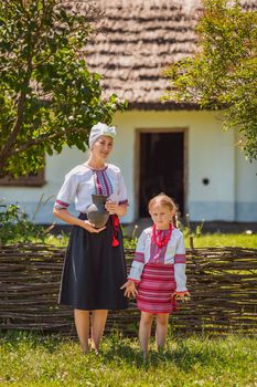 mother and daughter in Ukrainian national costumes near the fence