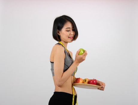 sporty fitness woman in sportswear with apple on white background. healthy sport lifestyle