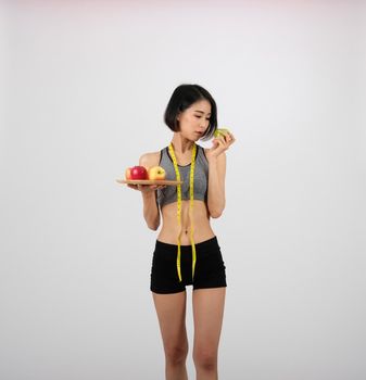 sporty fitness woman in sportswear with apple on white background. healthy sport lifestyle