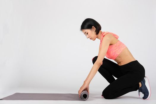 sporty fitness woman in sportswear with yoga mat on white background. healthy sport lifestyle