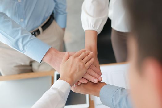 businessman businesswoman joining united hand, business team touching hands together after complete a deal in meeting. unity teamwork partnership corporate concept.