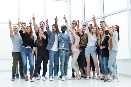 group of happy young people pointing upwards. photo with copy space